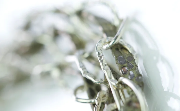 Soft-focus detail of silver-tone chain and clear crystal