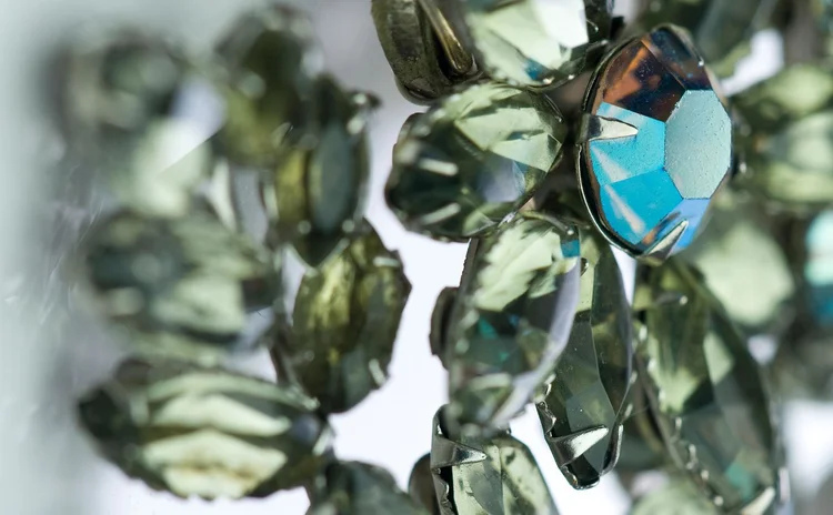 Detail of smoky gray navette crystal around a blue-green center stone