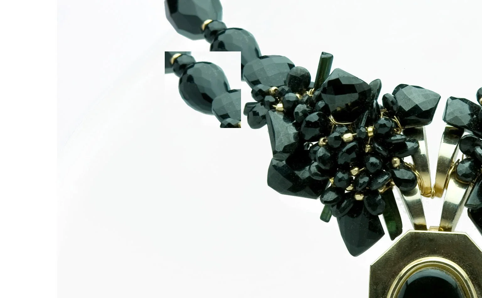 Black crystal cluster tapering into a gold-framed pendant