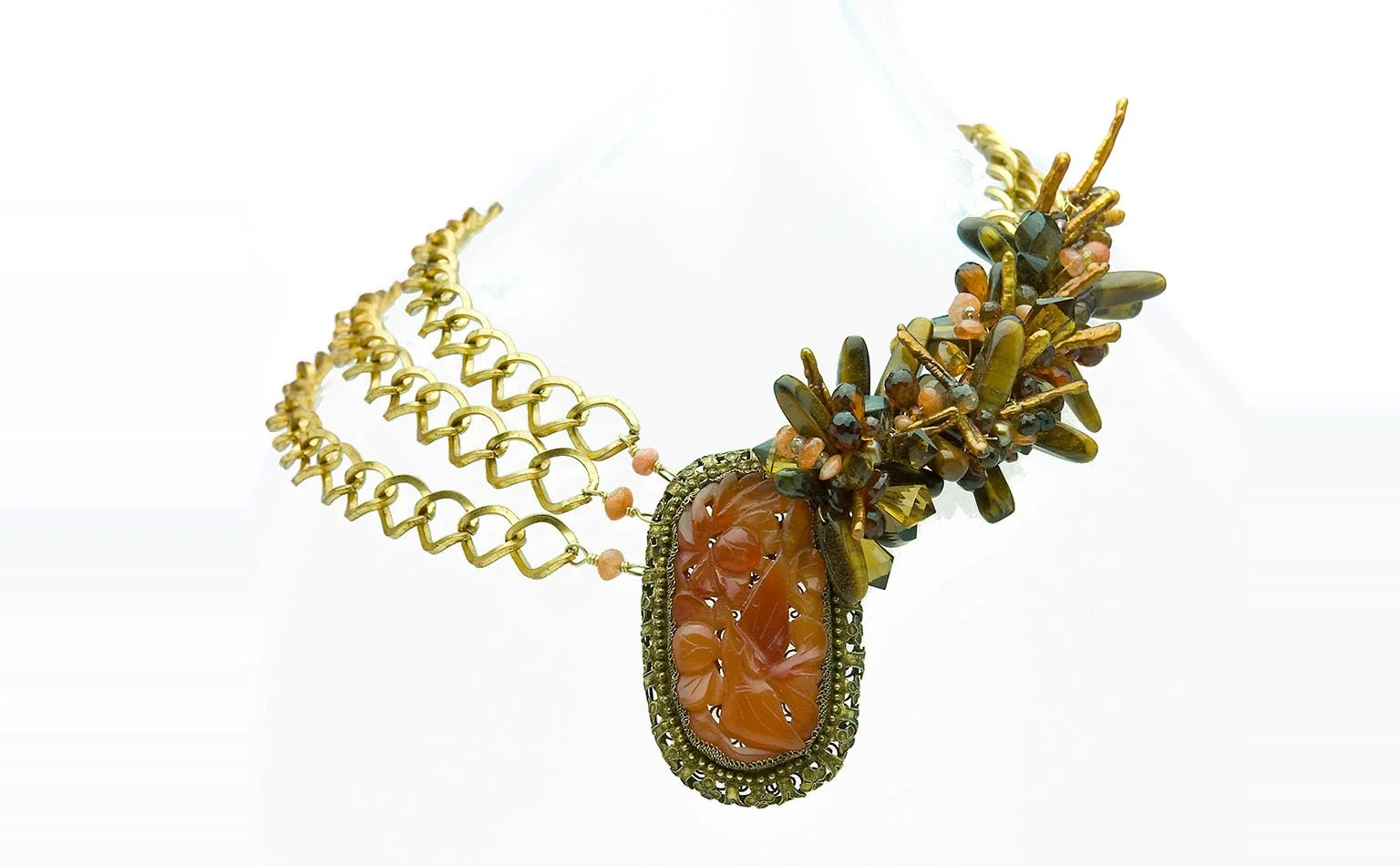 Gold chain necklace centered on a carved carnelian pendant 