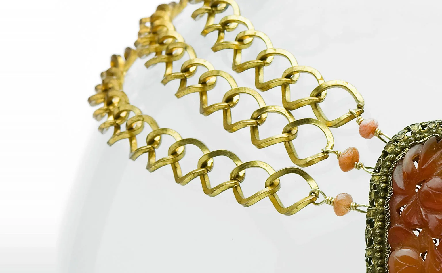 Gold-tone chain collar with a carved carnelian drop 