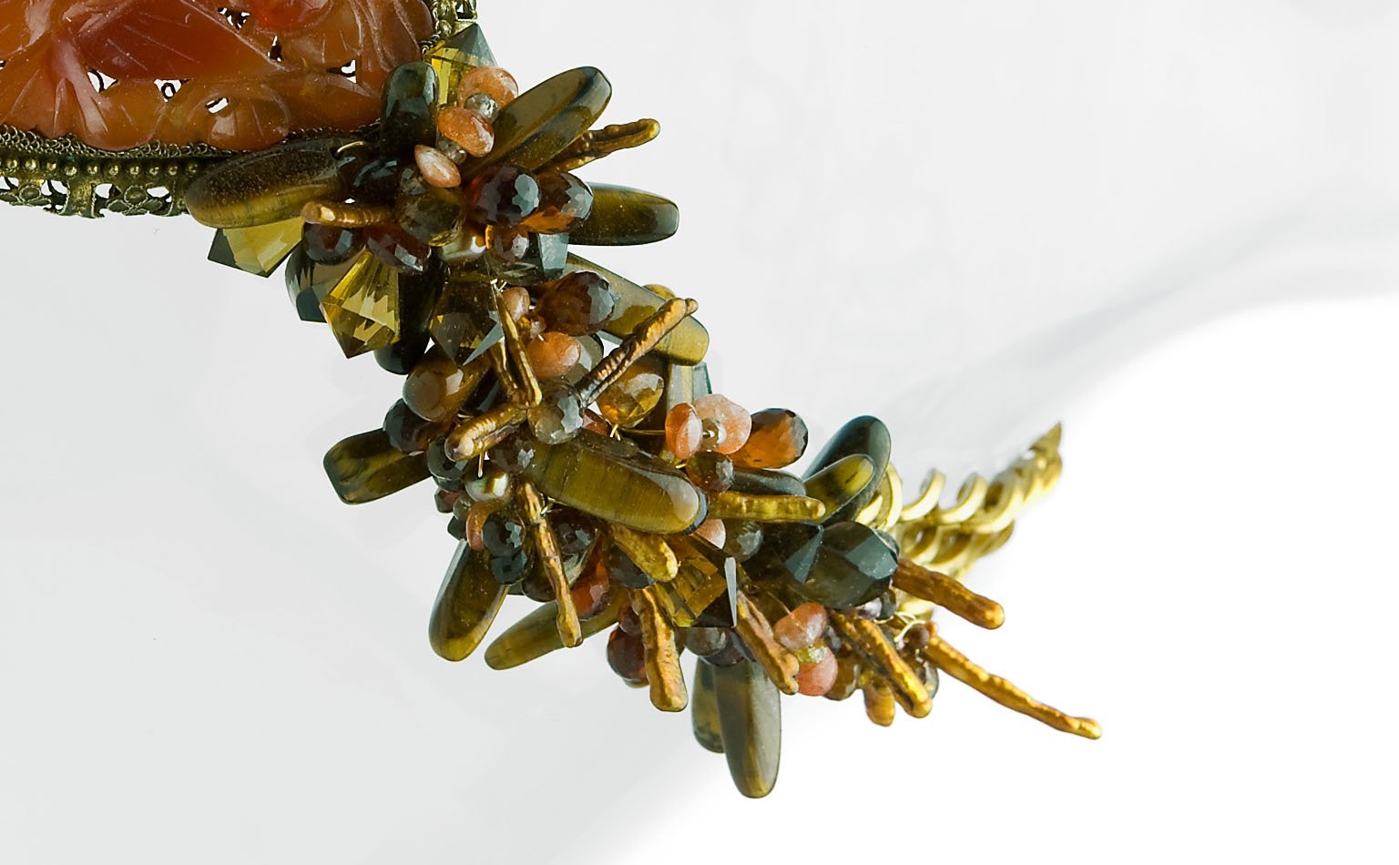 Detail of olive and coral beadwork against gold-tone chain 
