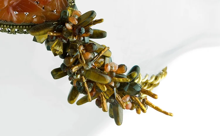 Detail of olive and coral beadwork against gold-tone chain