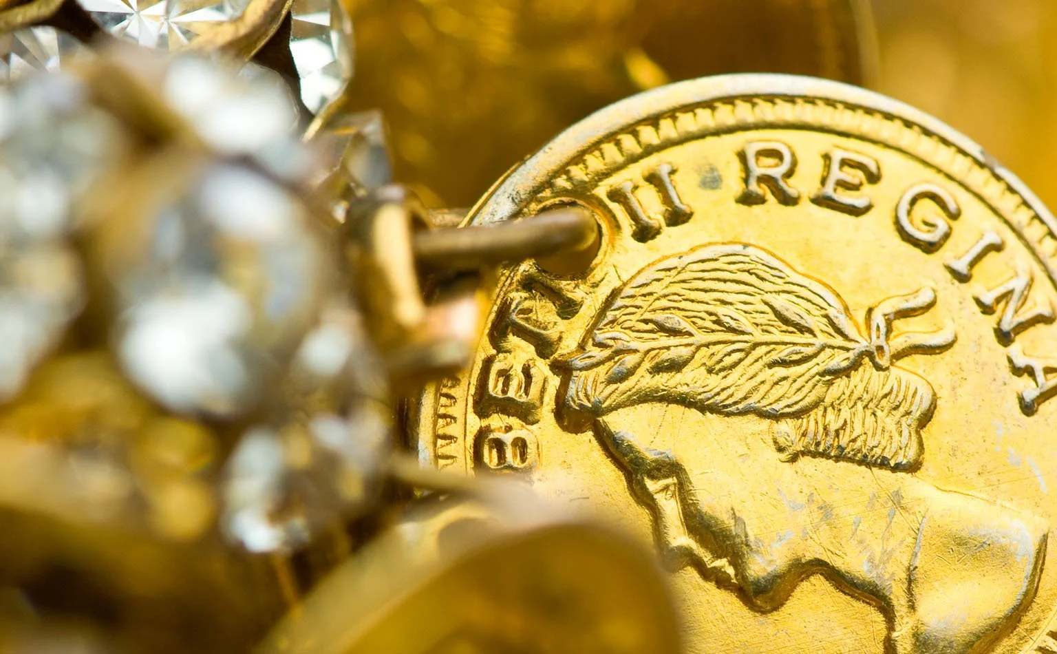 Detail of a portrait coin charm among gold links and rhinestone