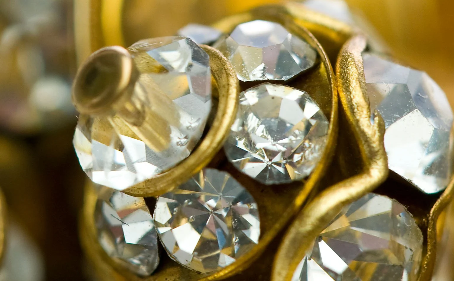 Detail of clear crystals set in a gold-tone claw mount