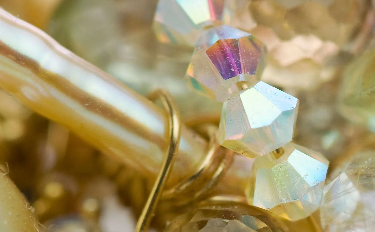 Detail of iridescent crystal beads against gold-tone metal 