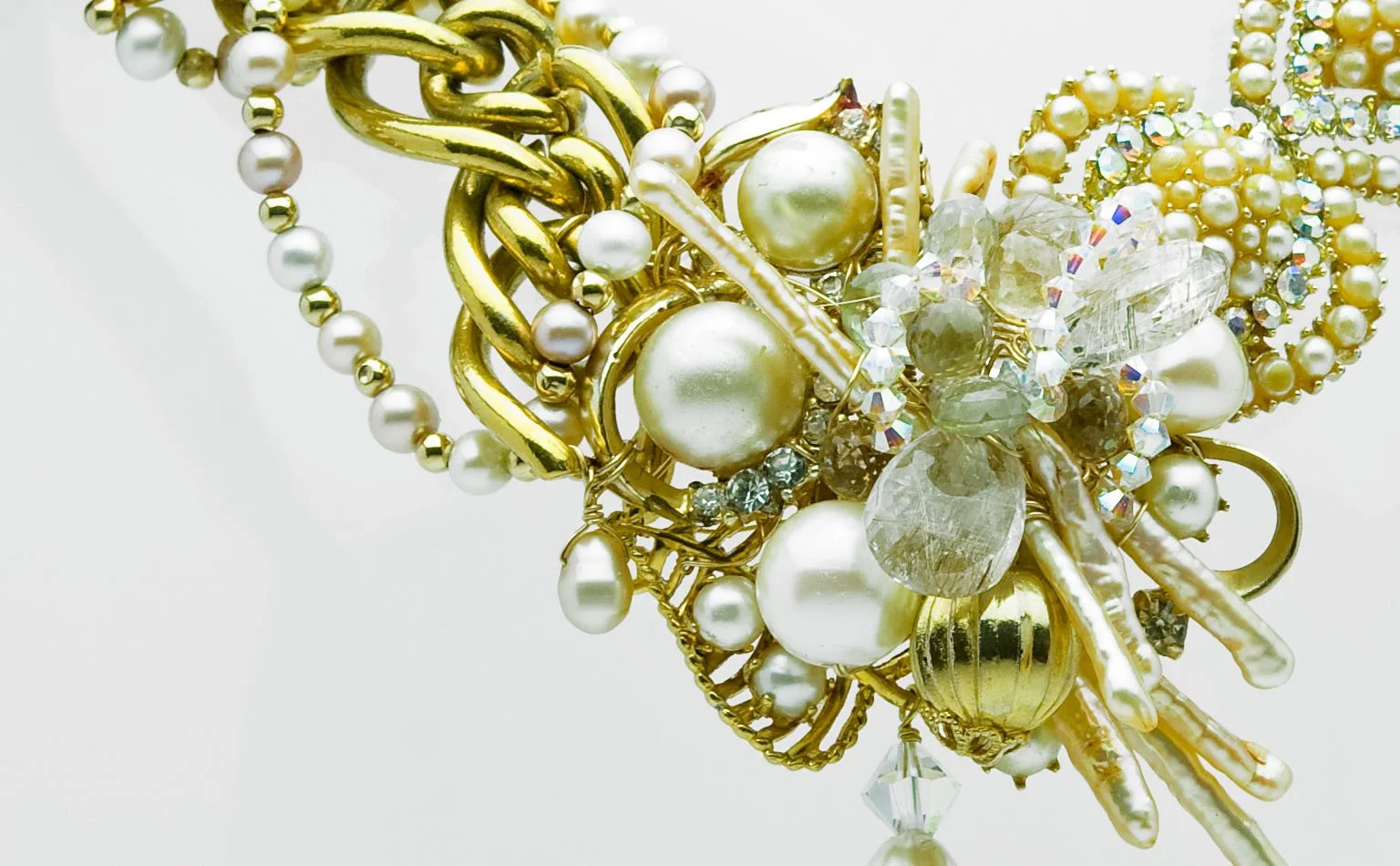 Detail of pearls, gold scrollwork and crystal on a collar front