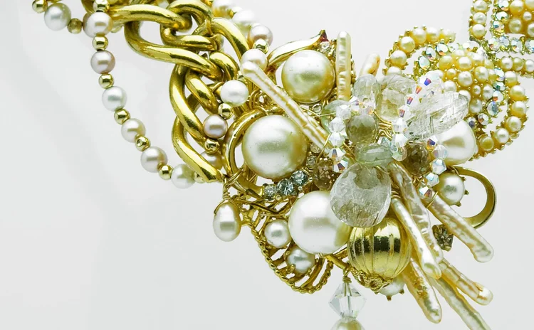 Detail of pearls, gold scrollwork and crystal on a collar front