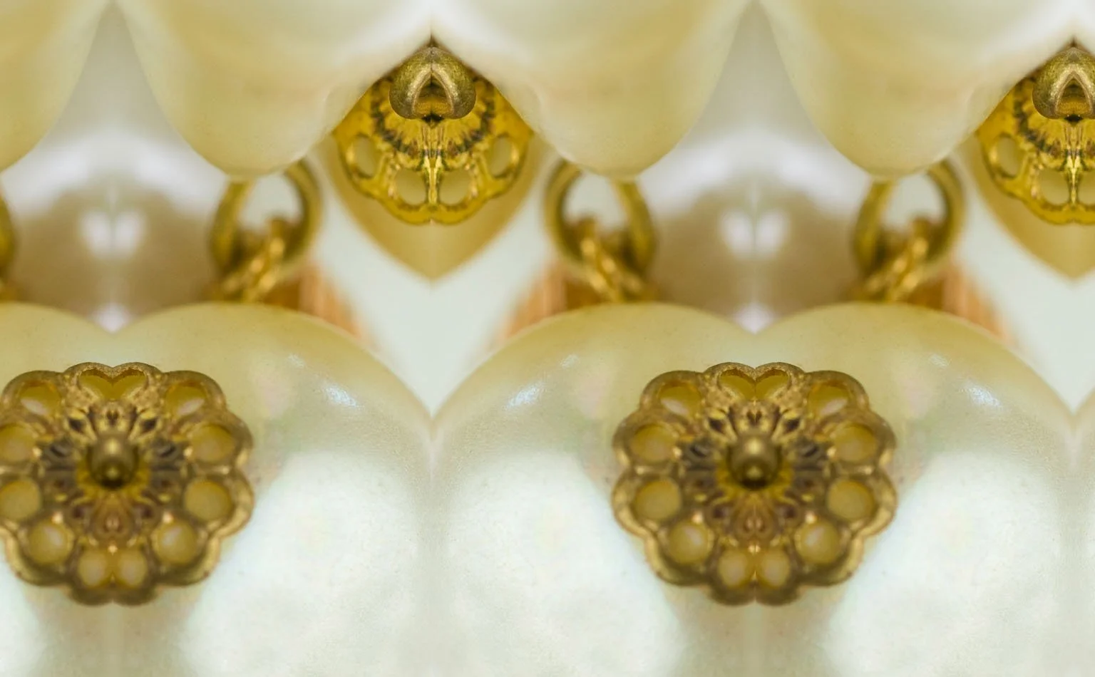 Detail of gold filigree caps repeated against pearl