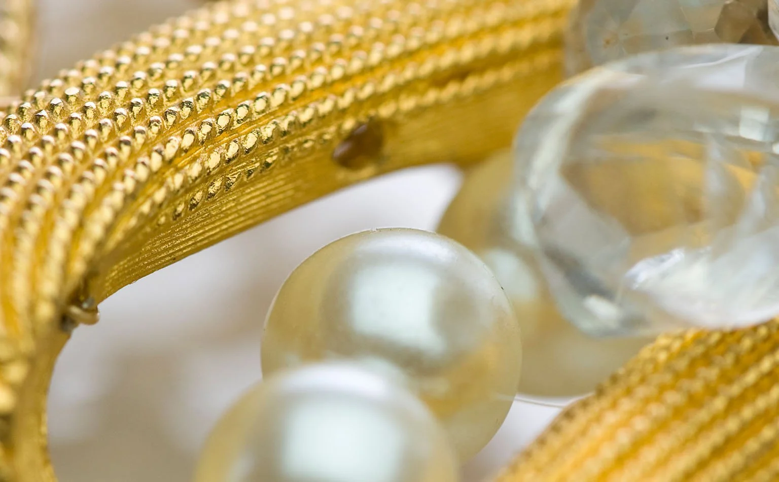 Detail of gold mesh banding beside pearls and clear crystal 