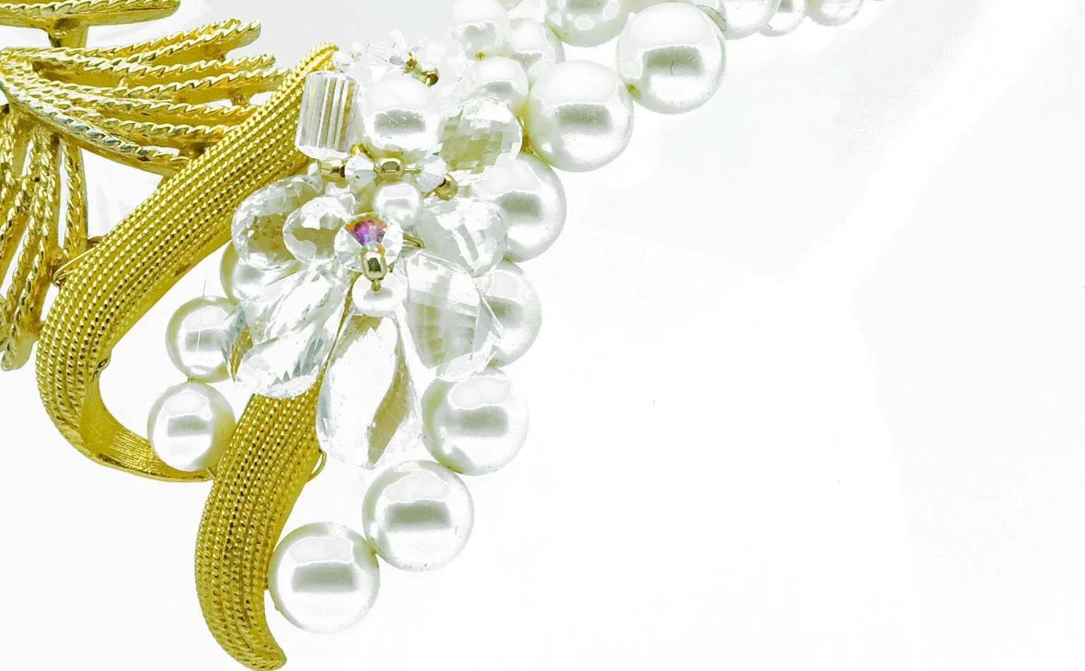 Detail of pearls and crystal massed against gold mesh 