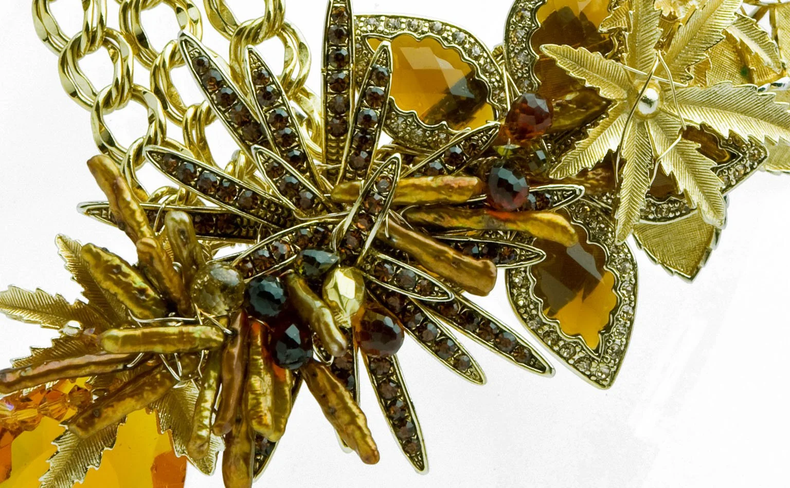 Detail of a gold starburst brooch form with dark crystal beading 