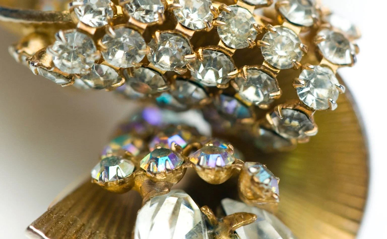 Detail of rhinestone rows curving over a fluted gold fan