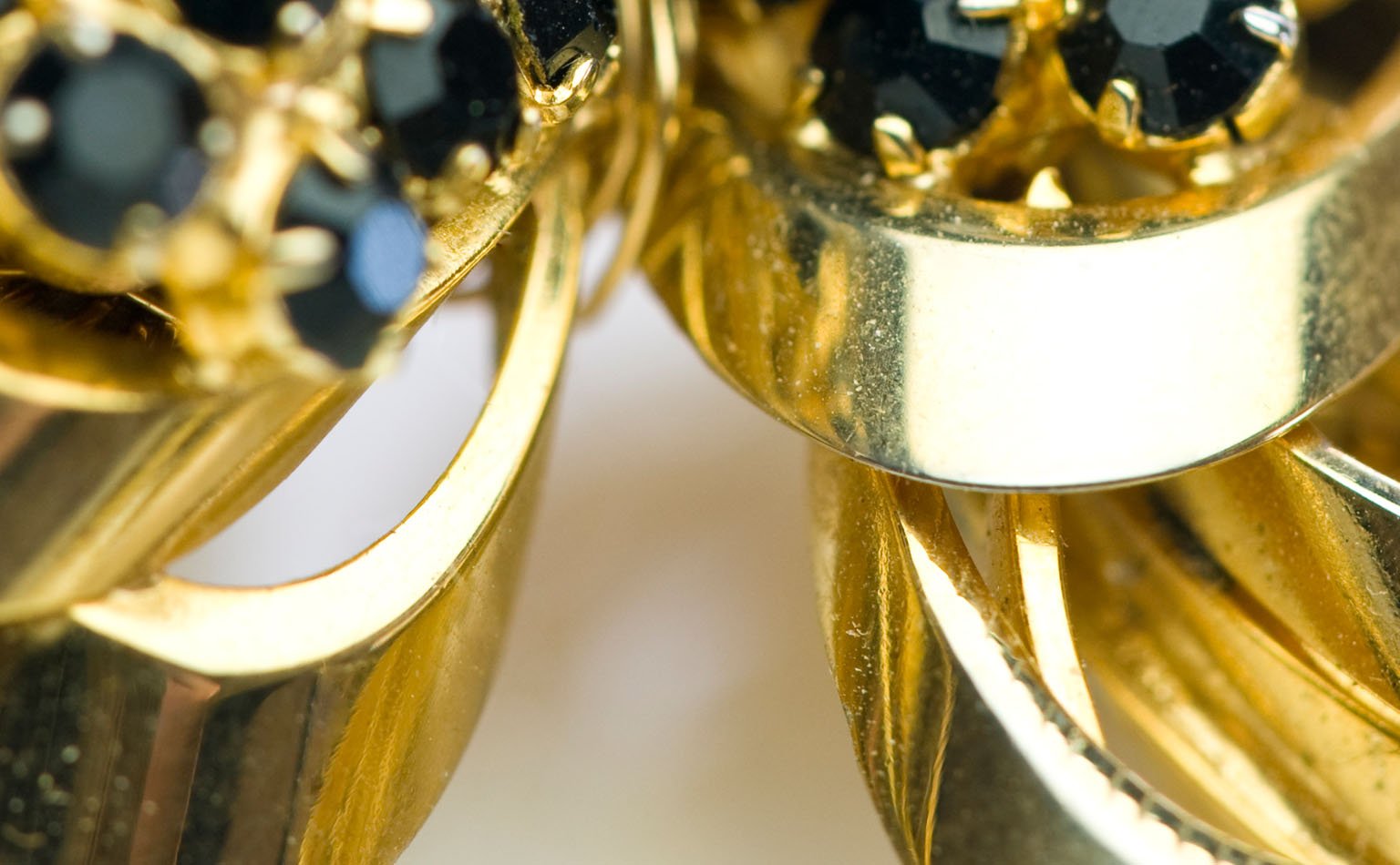 Detail of black crystal set into polished gold leaves