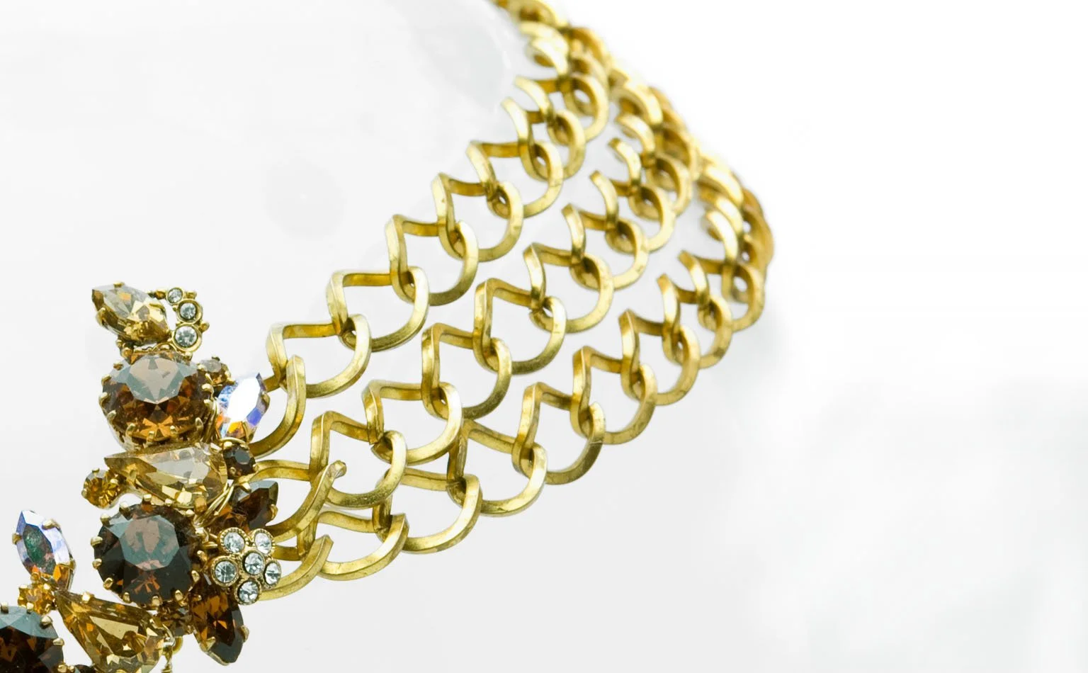 Detail of a wide gold chain band beside a crystal cluster