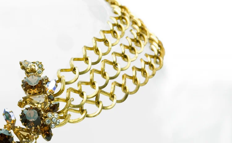 Detail of a wide gold chain band beside a crystal cluster