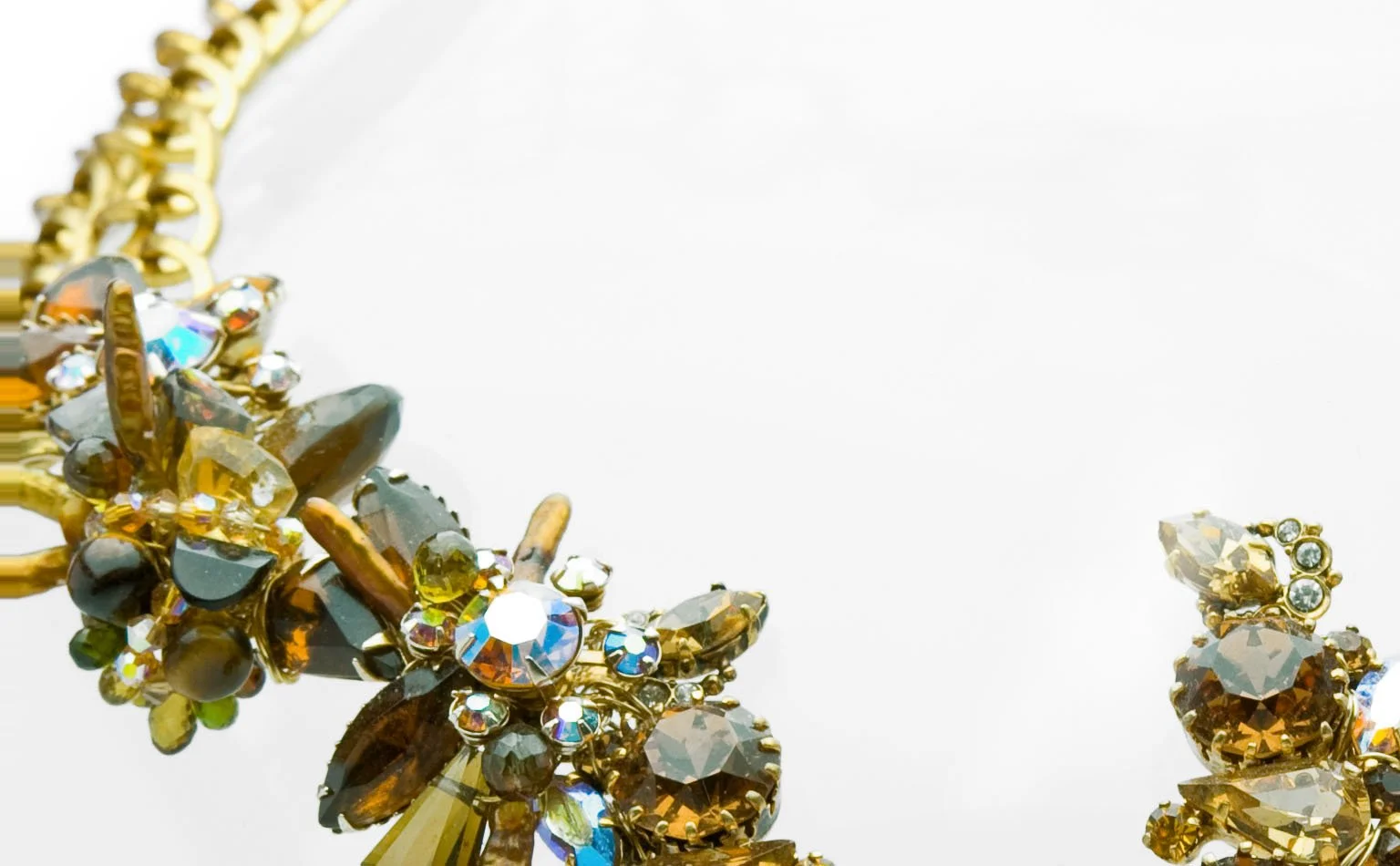 Detail of olive, amber and iridescent crystal massed on gold 