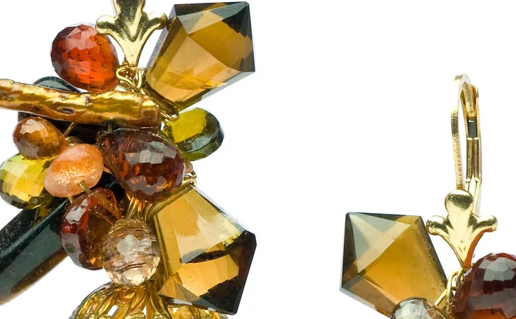 Detail of amber and topaz crystal clustered on a gold earring