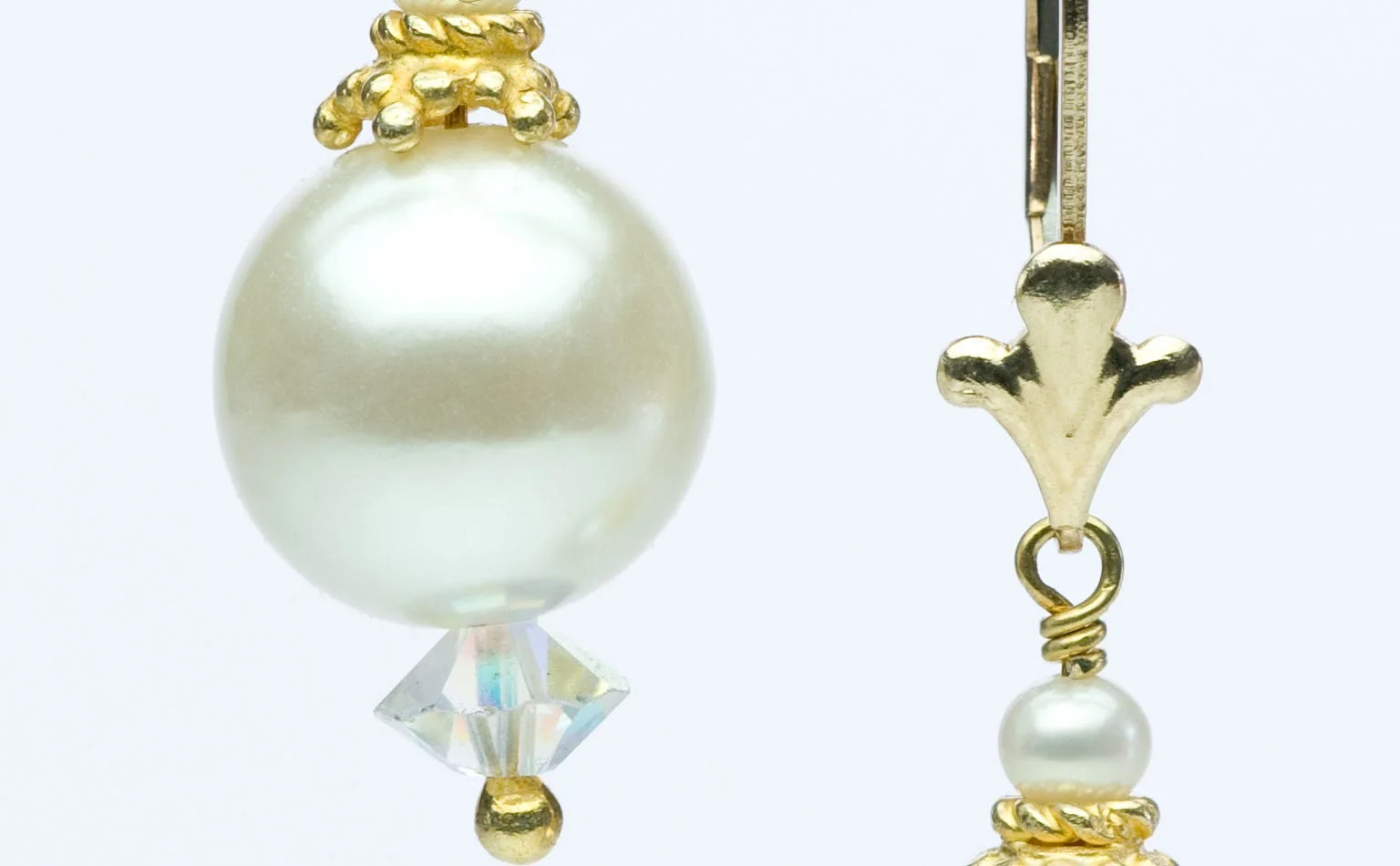 Pearl drop earrings with gold filigree caps, shown as a pair 