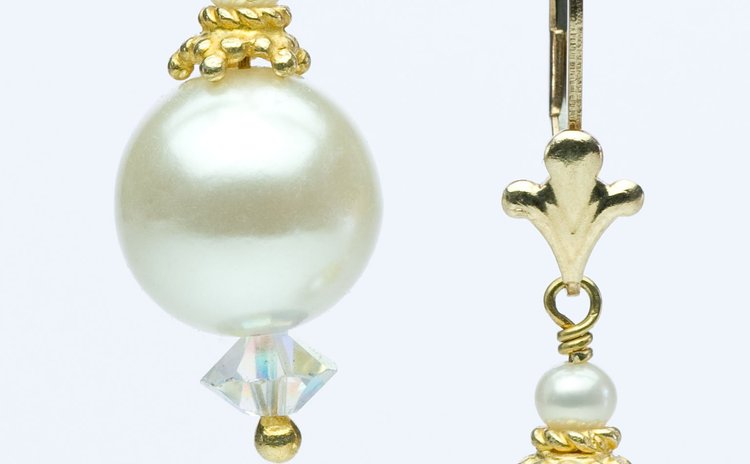 Pearl drop earrings with gold filigree caps, shown as a pair