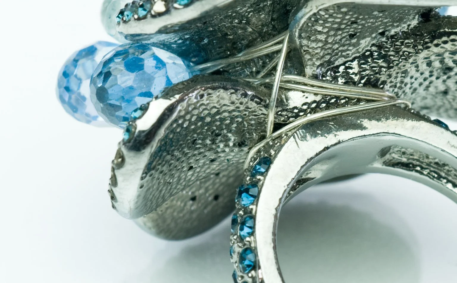 Detail of blue crystal briolettes on a pave silver-tone ring 
