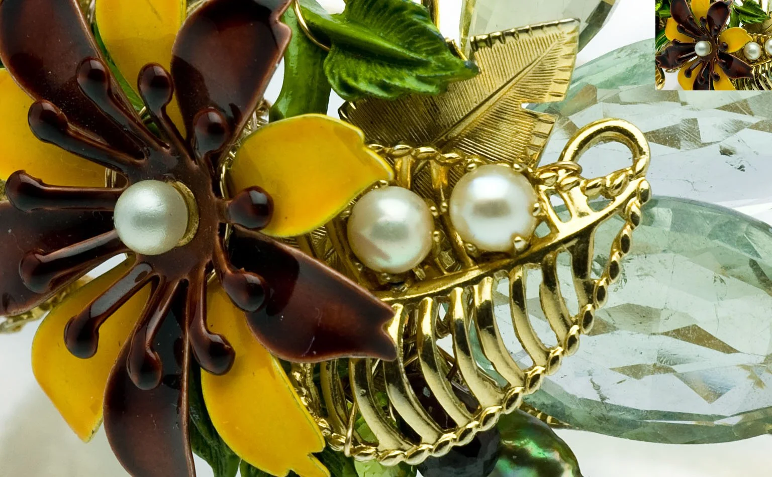 Detail of enamel flowers with pearl centers on a gold cuff 