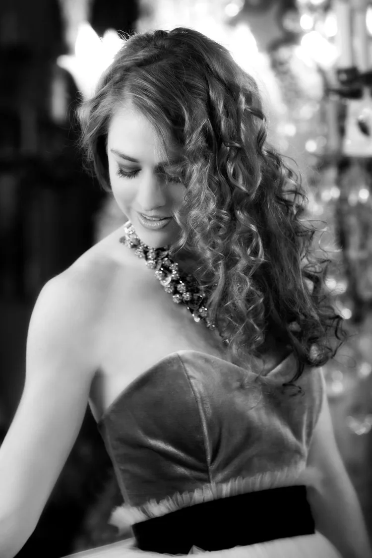 Black and white: a curly-haired model in a strapless dress and an Andrea Li statement necklace