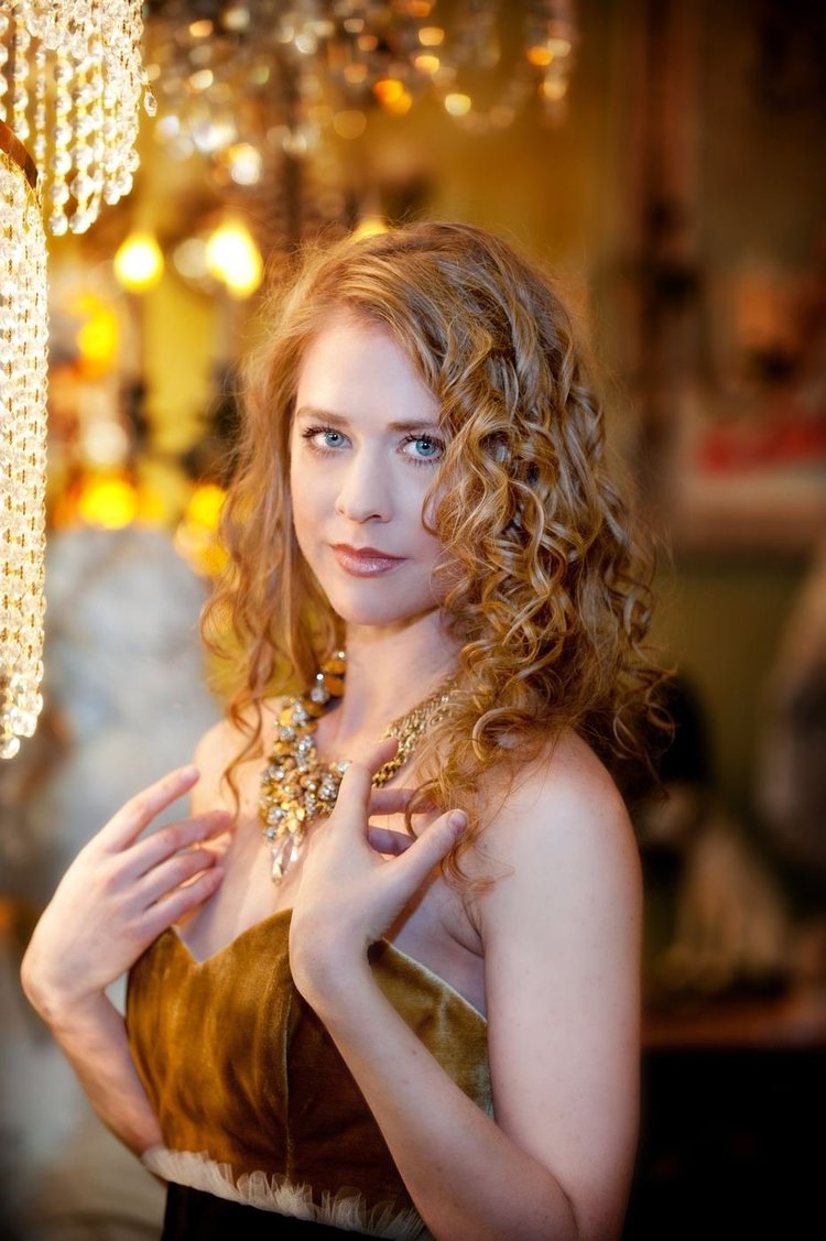 A red-haired model in a velvet strapless dress and an Andrea Li gold-tone statement necklace