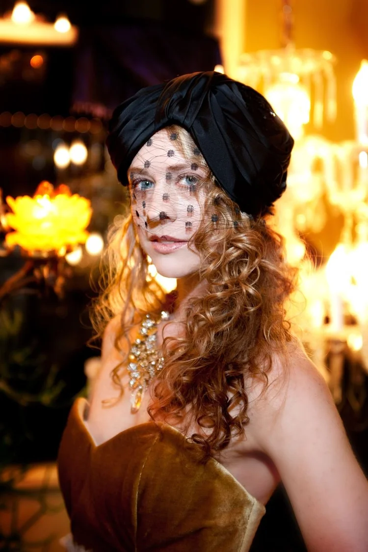 The red-haired model in a black turban and veil