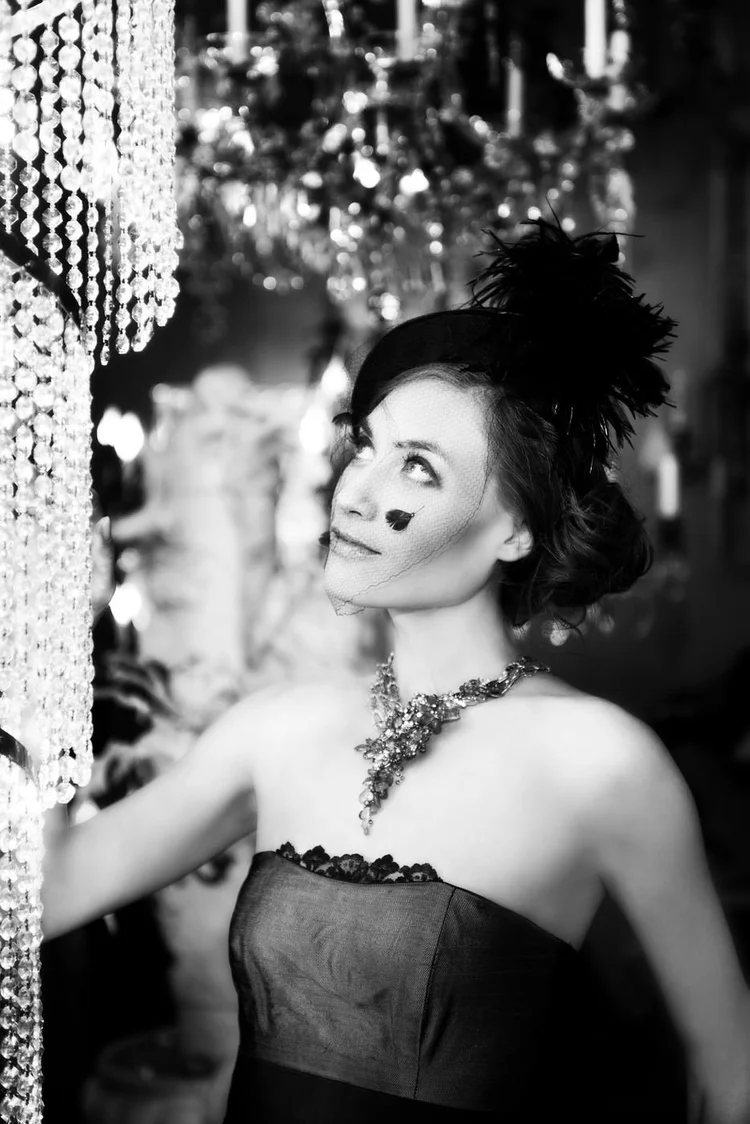 Black and white: a model in a feathered hat and an Andrea Li necklace