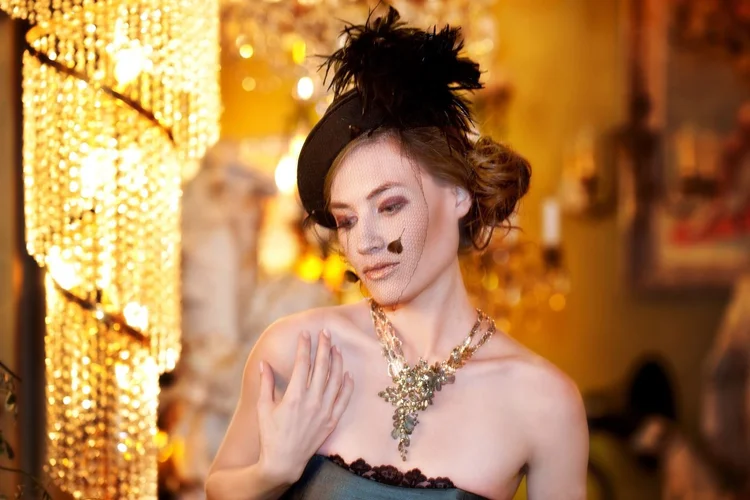 A model with a feathered hat among chandeliers, landscape view