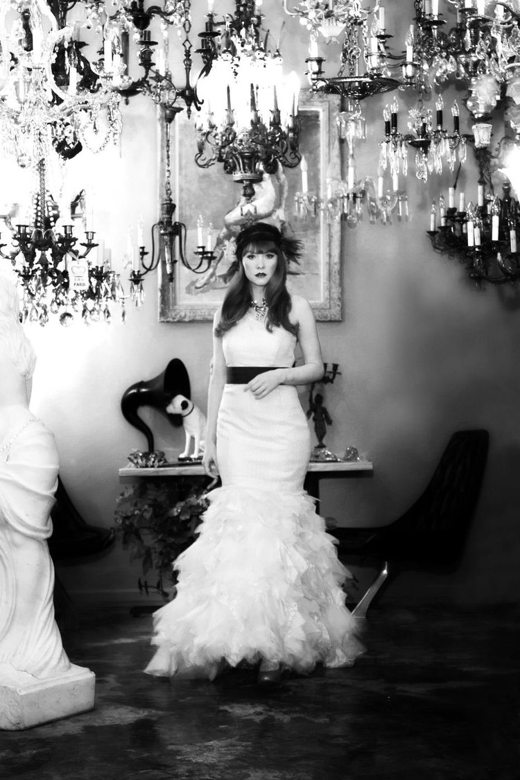 Black and white: a model in a white gown among chandeliers