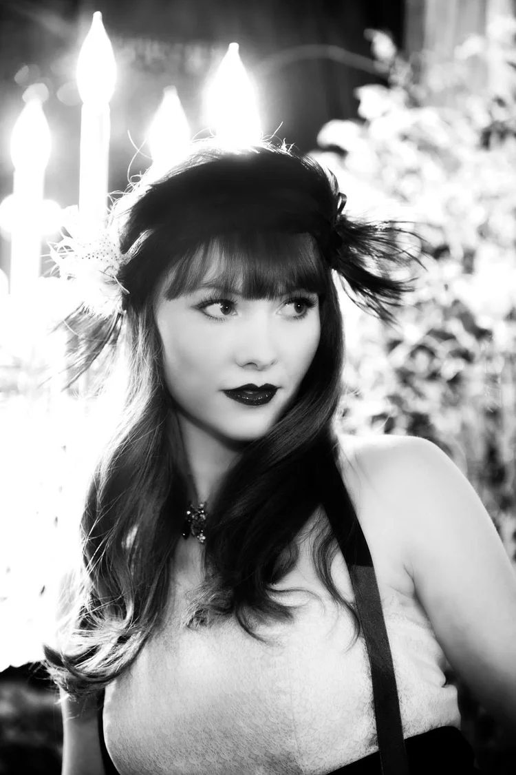 Black and white: a model with bangs and a feather headpiece