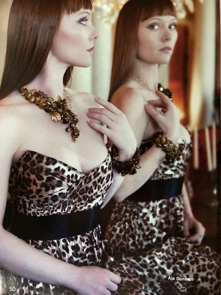 LUXZIO page 50: Aja Dunivan with her mirror double in a leopard dress, statement necklace and cuff