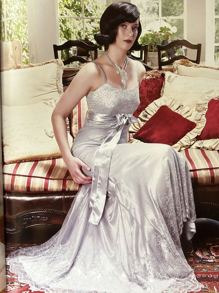 LUXZIO page 53: Marcia in a silver gown on a sofa wearing an Andrea Li crystal necklace