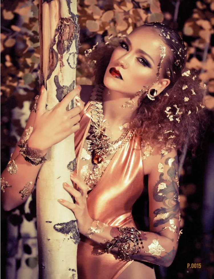 Kirameki #15 page 15: full-page gold-leaf image, the model at an aspen trunk in Andrea Li gold and crystal pieces