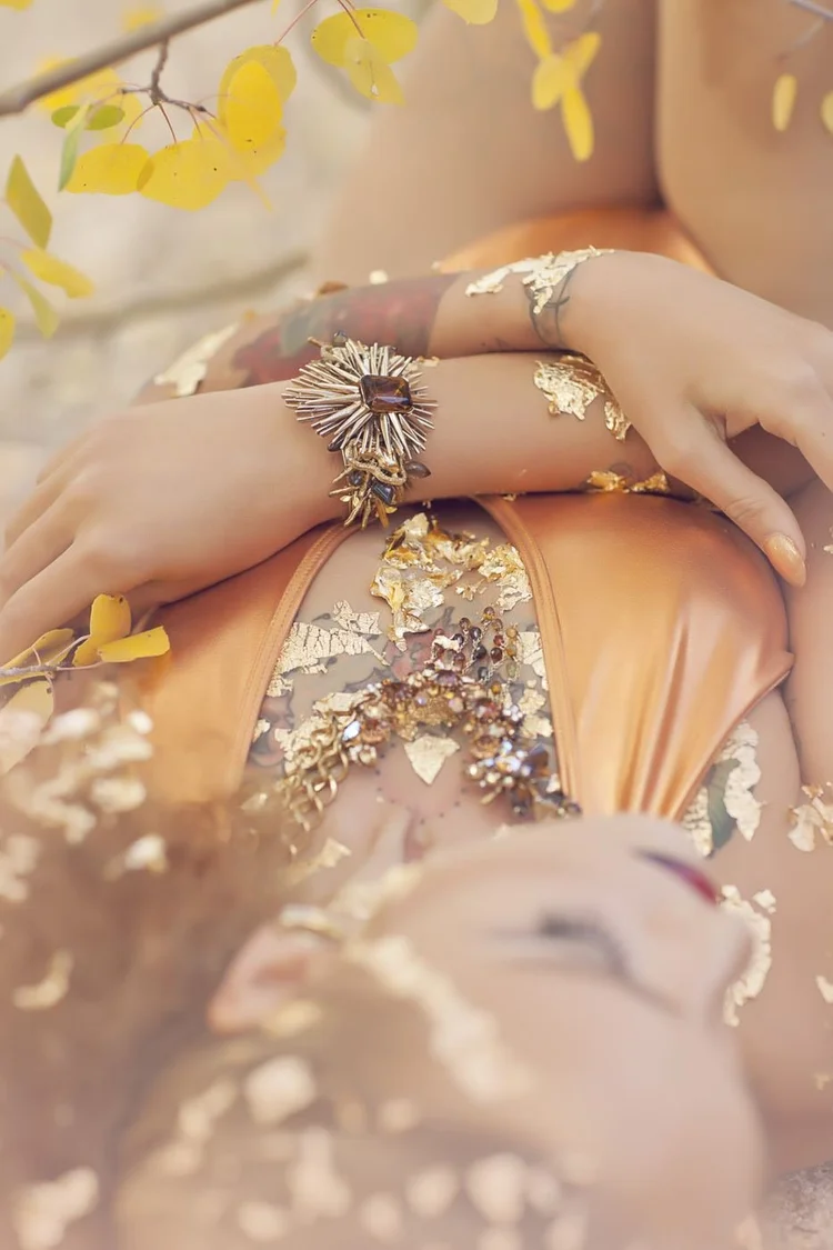 The model in gold leaf, hands crossed, Andrea Li cuffs and rings