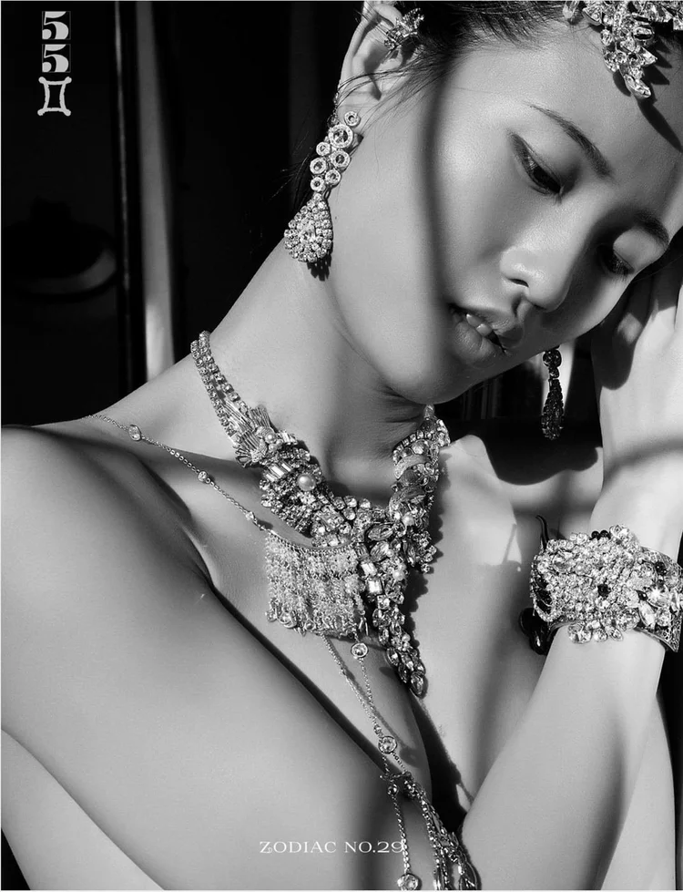 The Twins, page 54: Jade Mao, head bowed, in an Andrea Li crystal headpiece, chandelier earrings, layered crystal necklaces and a jeweled cuff