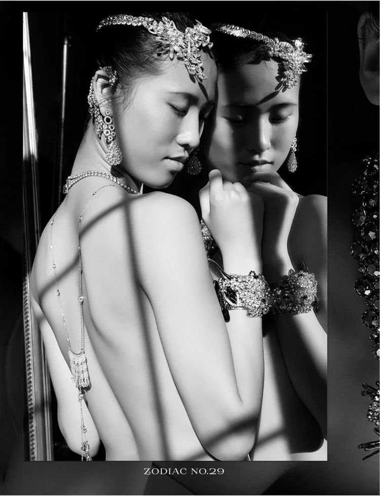 The Twins: the model leaning into a mirror, an Andrea Li back necklace and crystal cuff in window-frame shadows