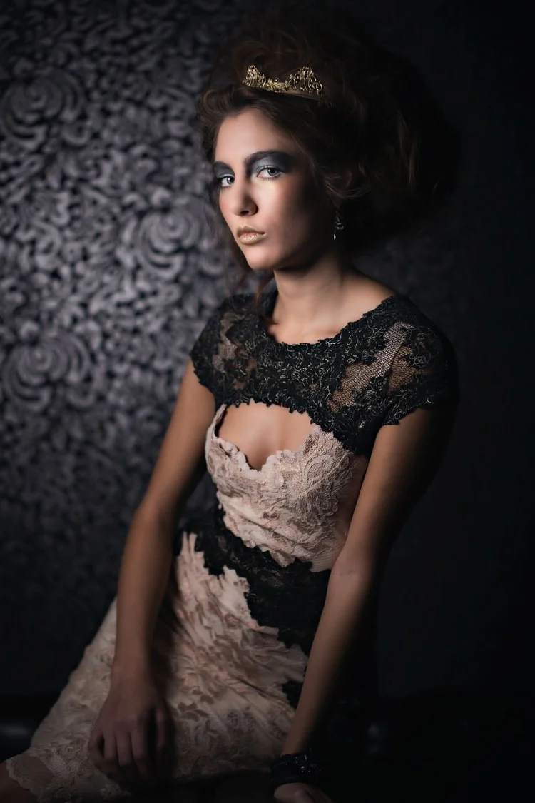 The model in black lace and a crown, seated