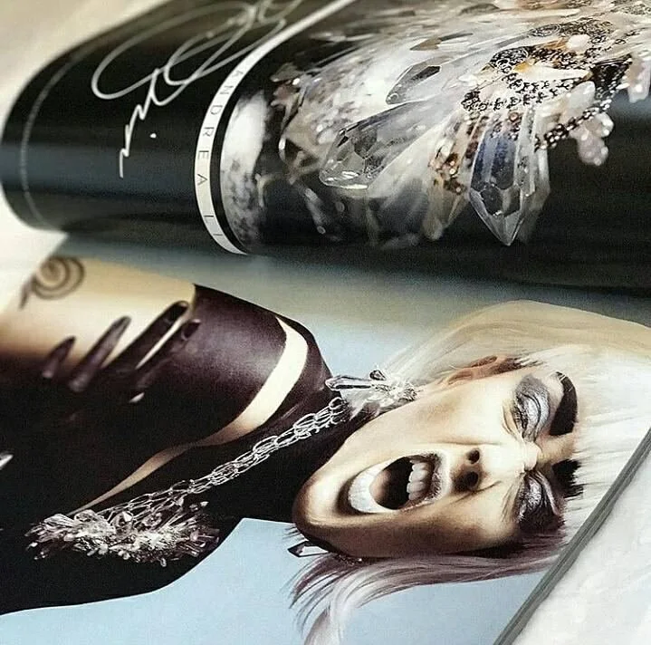 Photo of the printed DGARAY spread: the Andrea Li signature opener and a close-up of a crystal piece
