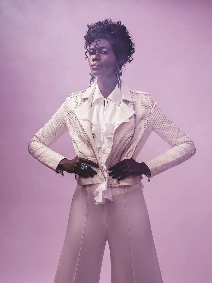 Purple Rain look: a model in a white ruffled suit on a lilac ground with Andrea Li jewelry