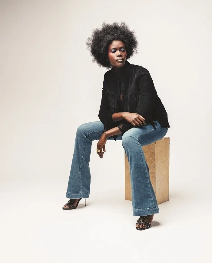 My Name Is Prince look: a model in a black fringe jacket and flared jeans wearing an Andrea Li ring