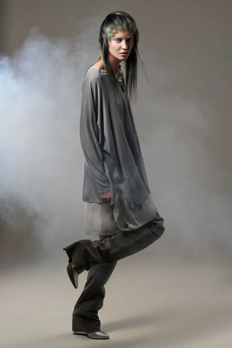 A model in a gray slouchy knit and leather pants in studio smoke