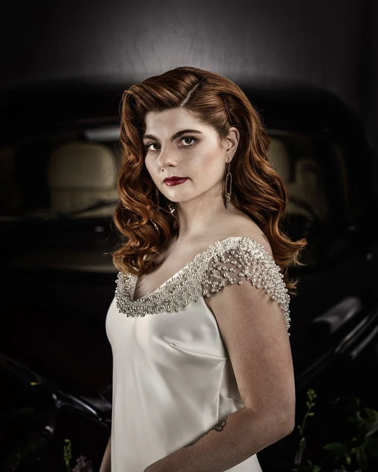 Close portrait of the red-haired bride, beaded shoulders