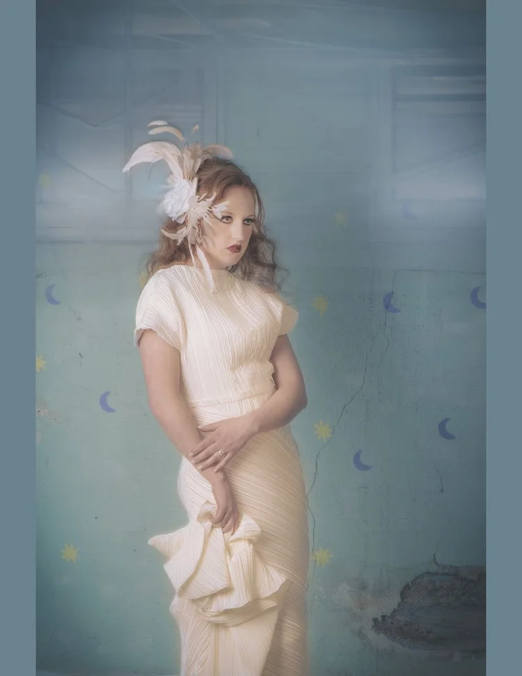 The model standing in a feather headpiece