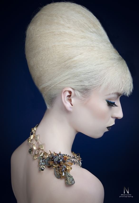 A model with a platinum beehive in profile wearing an Andrea Li gemstone cluster collar