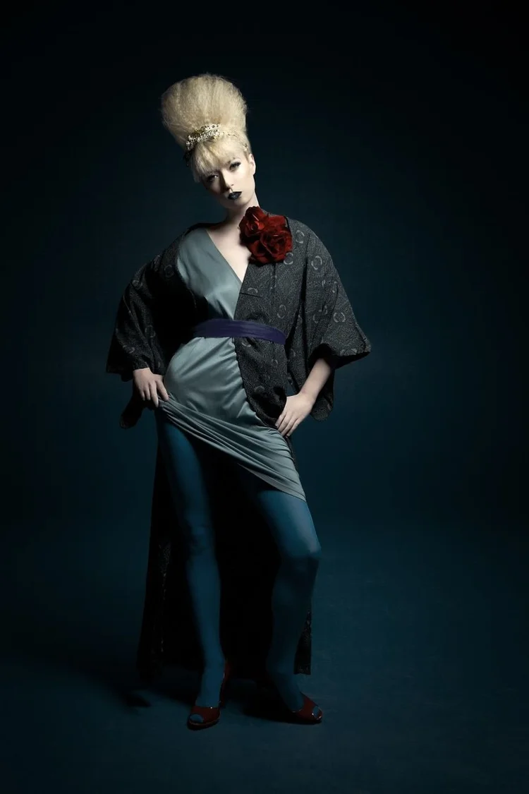 Full length in a gray robe with a red flower on a navy ground
