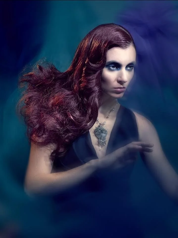 Long red hair and an Andrea Li pale blue stone pendant on a chain