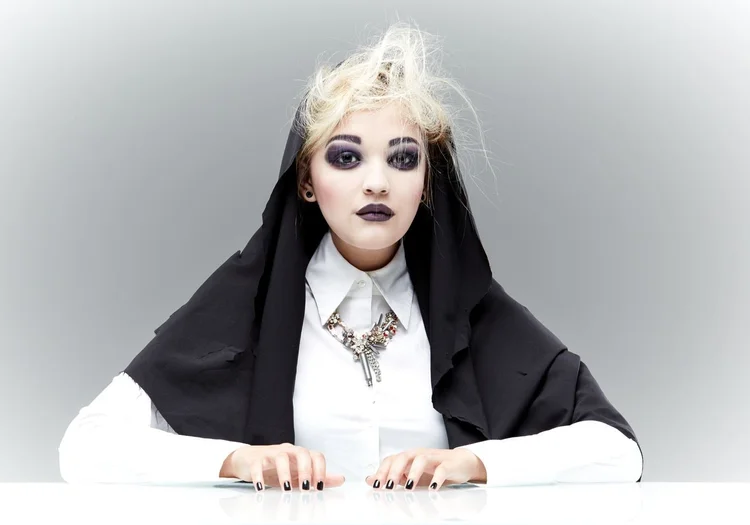 A model in nun-habit styling with a dark Andrea Li pendant